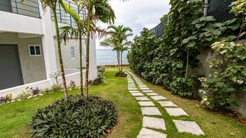 A pathway leading to a modern building with a view of the ocean.