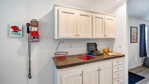 A kitchen with white cabinets, a granite countertop, a red telephone, and a coffee maker. - Water Slide, Swim Mat, Kayaks! PET FRIENDLY - Retro Weeki Wachee River! (Weeki Wachee)
