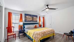 A bedroom with a bed, two nightstands, a desk, a chair, and a ceiling fan. - Water Slide, Swim Mat, Kayaks! PET FRIENDLY - Retro Weeki Wachee River! (Weeki Wachee)