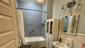 Ein Badezimmer mit einer Badewanne, einer Dusche, einer Toilette und einem Waschbecken.