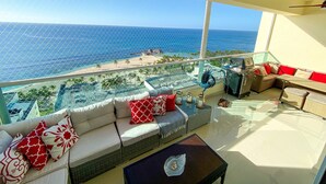 A balcony with a view of the ocean, a sofa with patterned cushions, and a table with a decorative item. - Spacious Apto With Spectacular Views Of The Beach (Guayacanes)