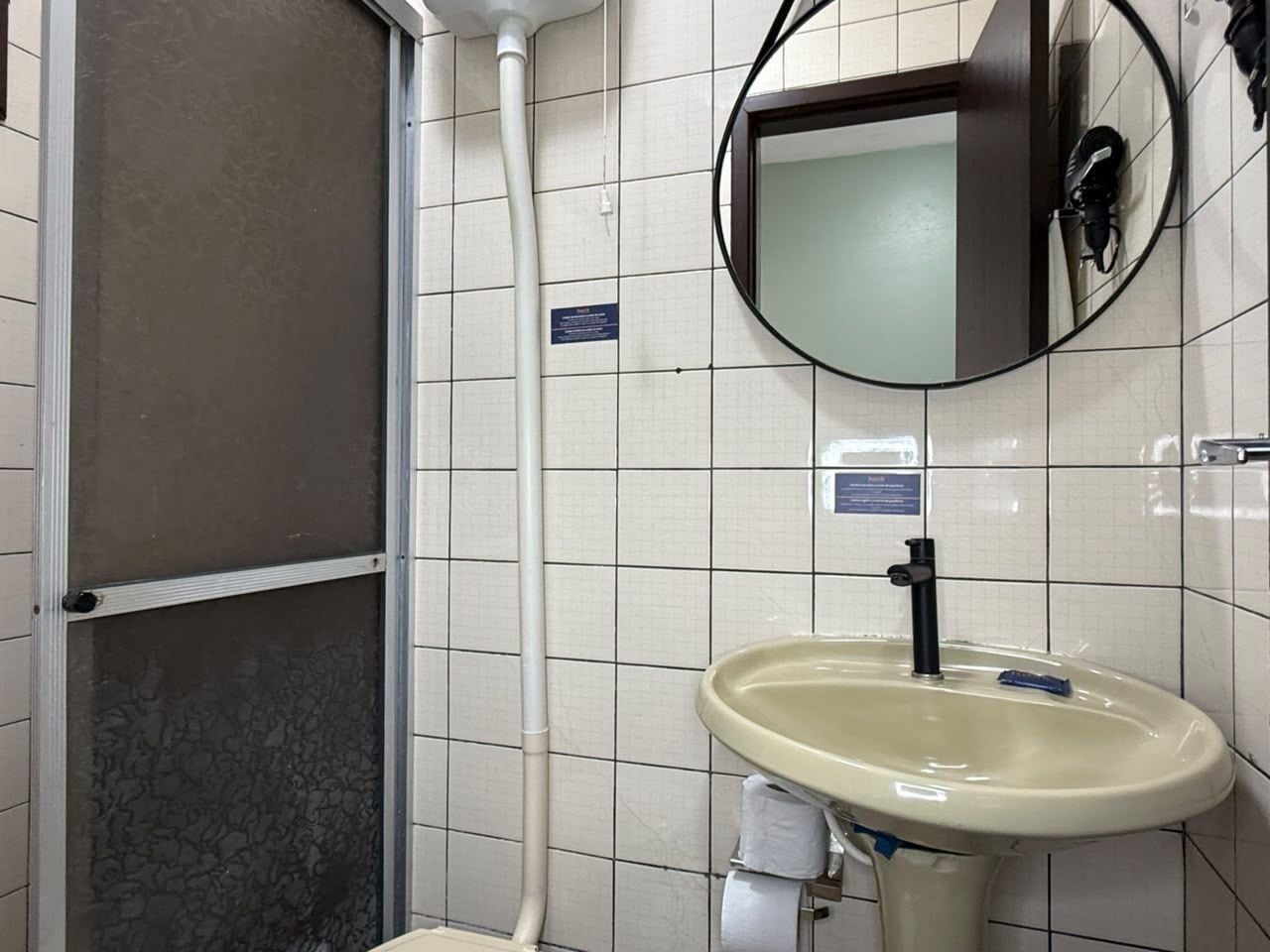 Une salle de bain équipée d’un lavabo, d’un miroir et d’une cabine de douche.