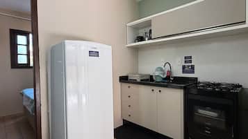 A compact kitchen with a refrigerator, stove, and sink.