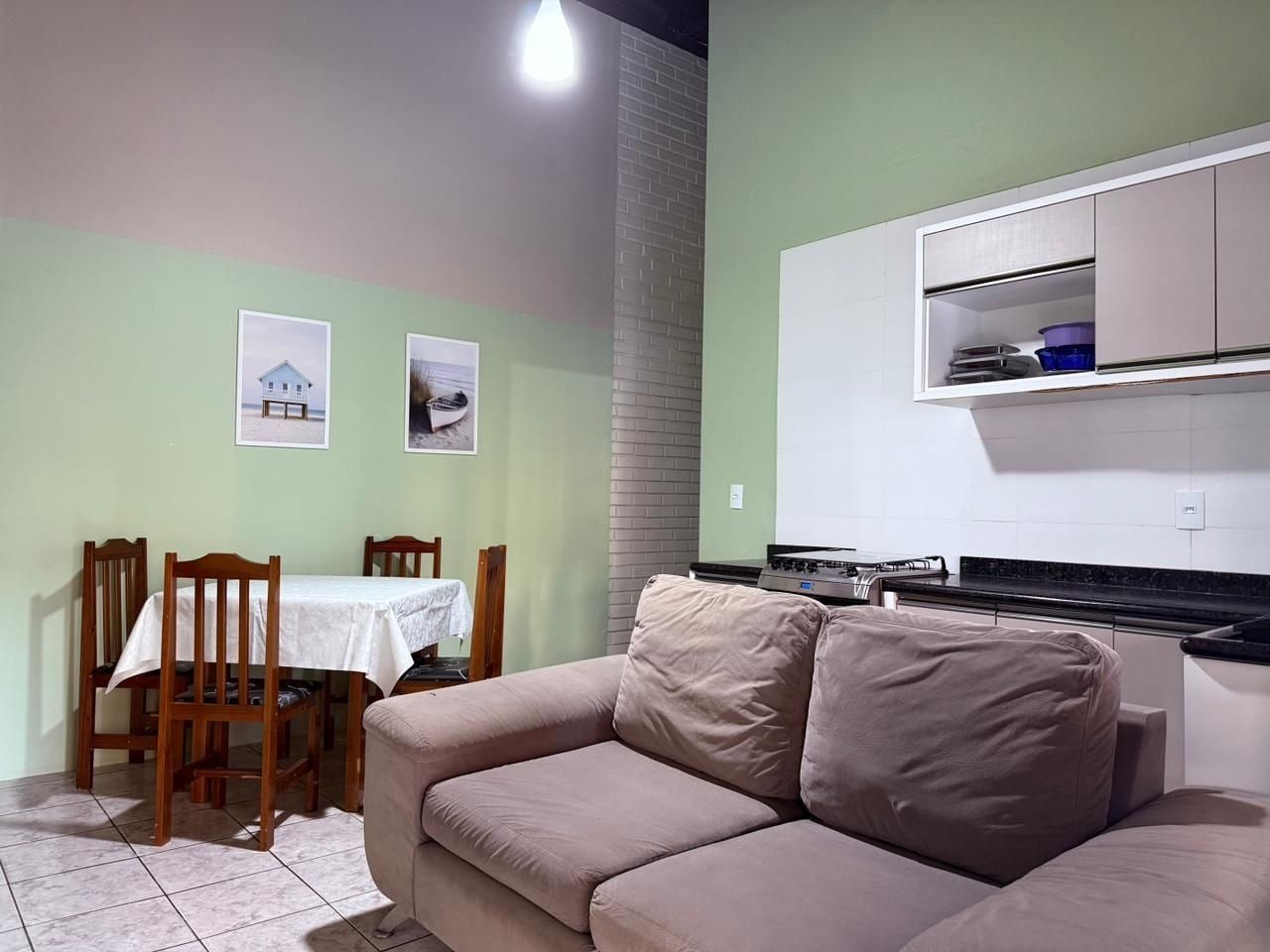 A compact living space with a dining area, a kitchenette, and a sofa.