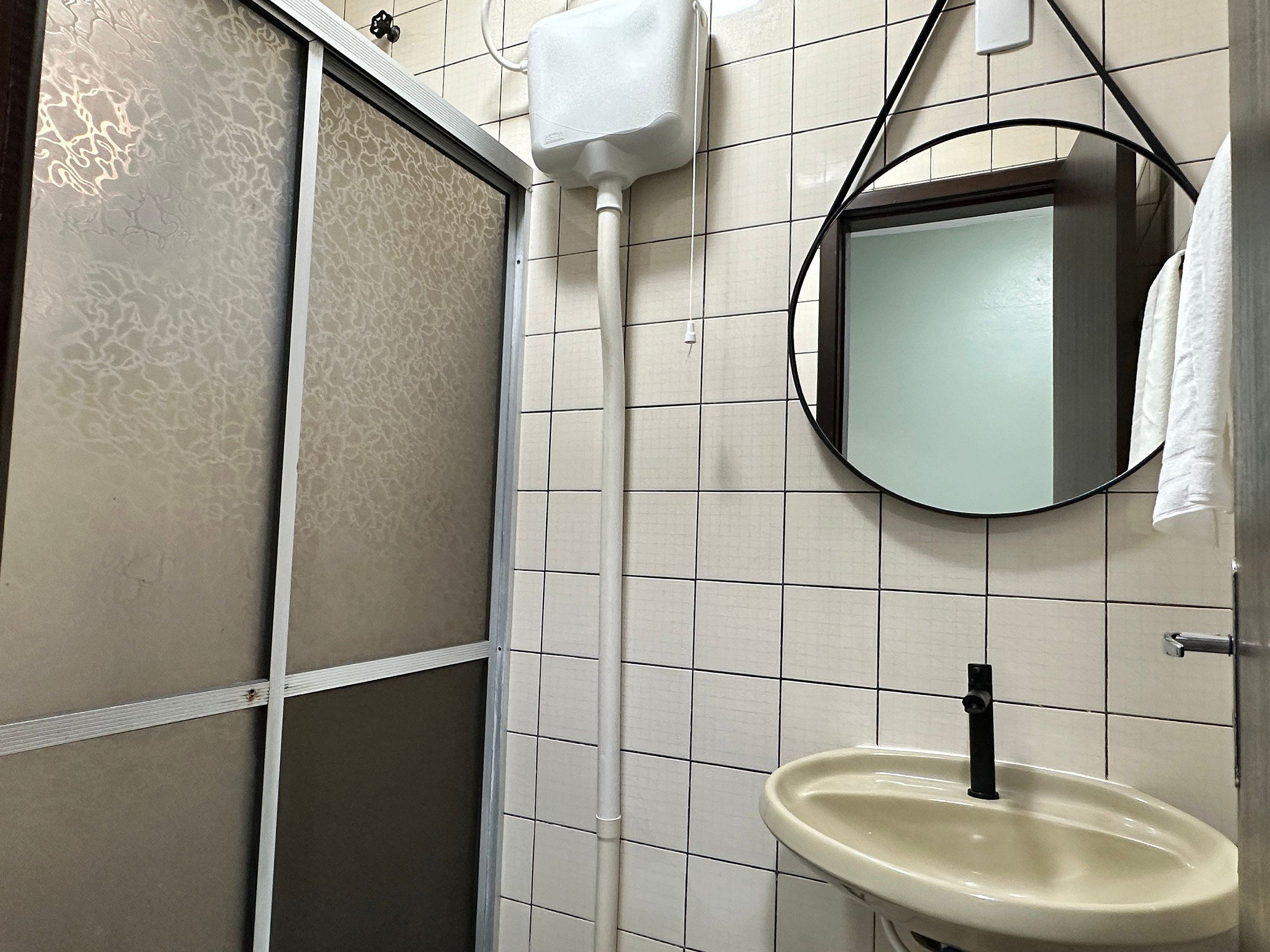 Ein Badezimmer mit Toilette, Waschbecken, Spiegel und Handtuchhalter.