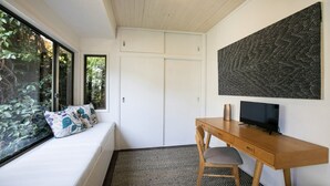 A room with a bed, a desk with a chair, a TV, and a large abstract painting on the wall. - Bush setting and easy walk to beach (KILLCARE)