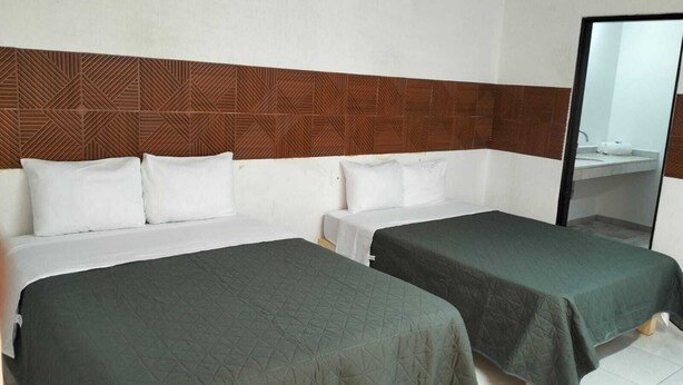 A hotel room with two single beds, a wooden headboard, and a large mirror. - RESIDENCIA CASA BLANCA (Querétaro)