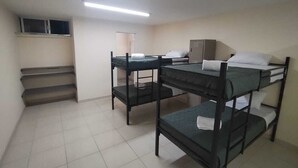 A dormitory room with bunk beds, a desk, a chair, and a small window. - RESIDENCIA CASA BLANCA (Querétaro)