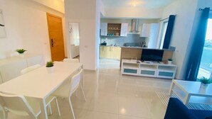 A modern apartment with a dining area, kitchen, and living space. - Apartamento Acogedor Cerca de la Playa (Boca Chica)
