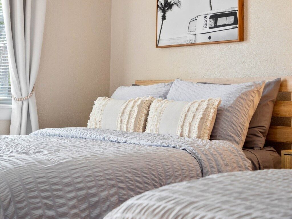Una cama bien hecha con una colcha acolchada y varias almohadas.