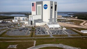 Una gran instalación de la NASA con un edificio alto que muestra el logotipo de la NASA y la bandera estadounidense.