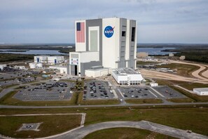 Ein großes NASA-Gelände mit einem hohen Gebäude, das das NASA-Logo und eine amerikanische Flagge zeigt.