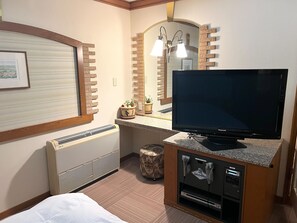 A hotel room with a bed, a television, a mirror, a small table, and a waste bin. - Hotel Ange (Fukuyama)