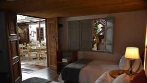A cozy room with two beds, a wooden ceiling, and a small table with a lamp. - La Estancia Hotel Boutique  (Salamina)