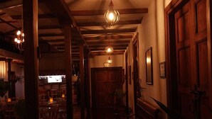 A dimly lit hallway with wooden beams and a bench. - La Estancia Hotel Boutique  (Salamina)