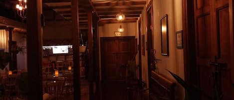 A dimly lit hallway with wooden beams and a bench.