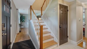 A staircase with wooden steps and white railings, leading to an upper floor.