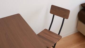 A wooden chair with a high backrest and a table with a wooden surface.