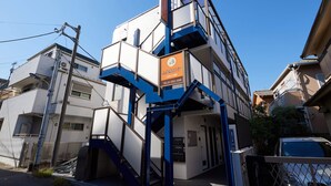 Ein mehrstöckiges Gebäude mit blau-weißer Farbgebung, mit einem Schild mit Kontaktinformationen.