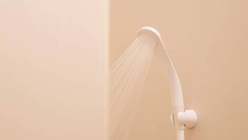 Kombinasi shower/bathtub, pengering rambut, sandal, dan handuk