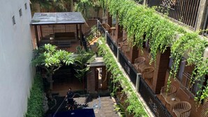 Una piscina en la azotea rodeada de vegetación y un edificio de ladrillo.