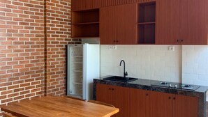 Una cocina moderna con armarios de madera, una encimera negra y una mesa de comedor de madera con sillas.