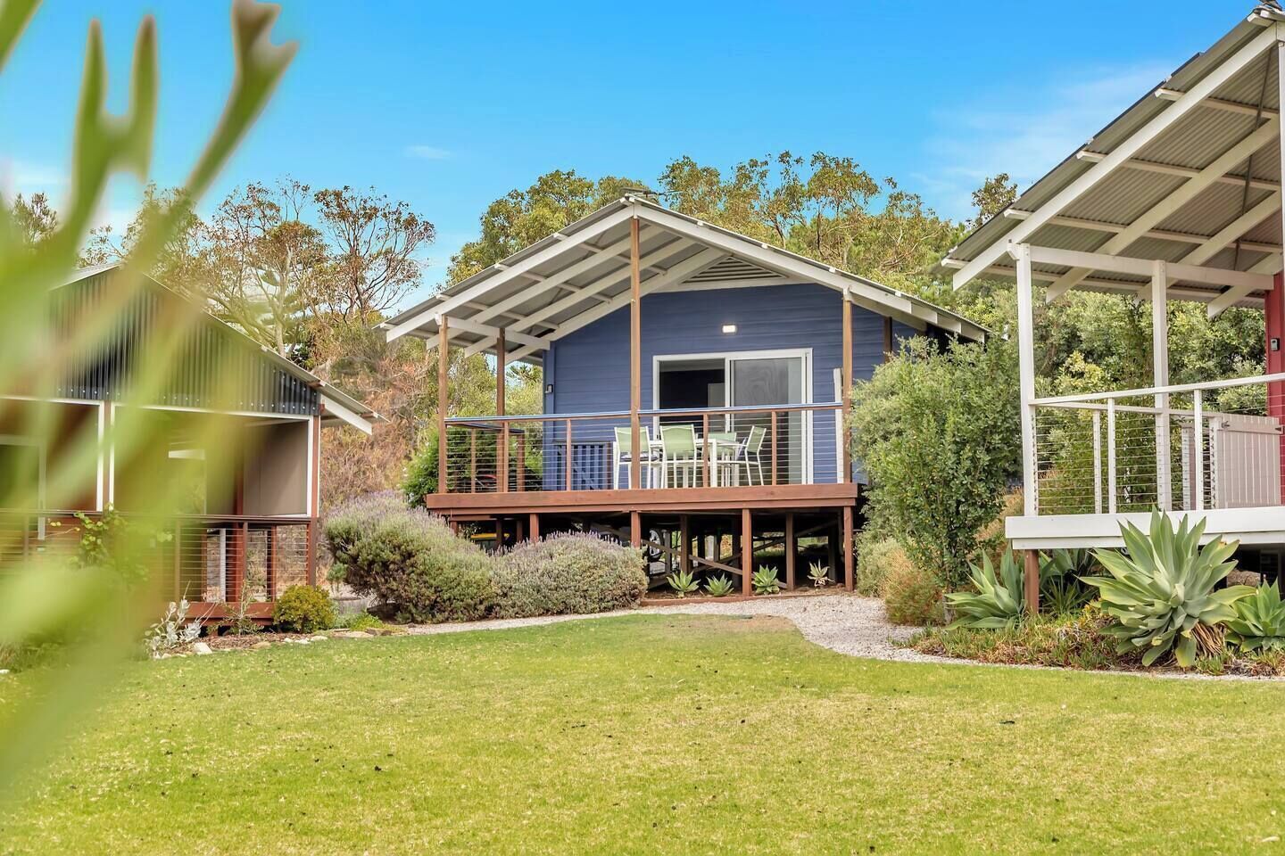 This blissful blue cabin enjoys a prime address just footsteps from the sand and sea.
