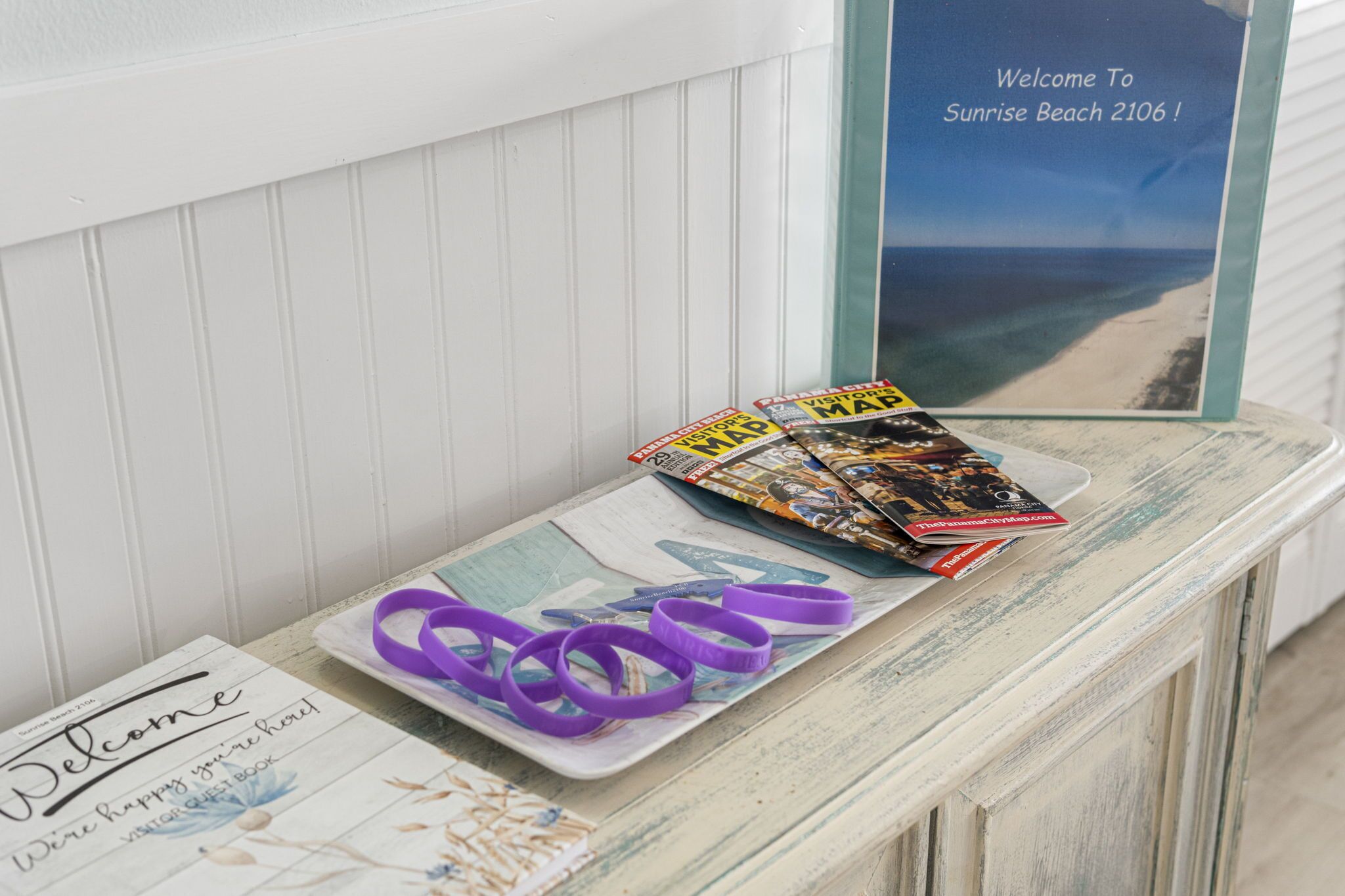 A welcome sign, a magazine rack with travel magazines, and a view of the beach.