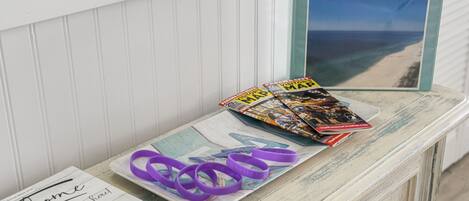 A welcome sign, a magazine rack with travel magazines, and a view of the beach.