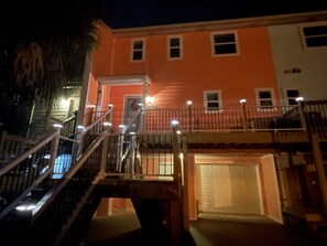 A multi-story building with a staircase, a balcony, and a garage entrance.