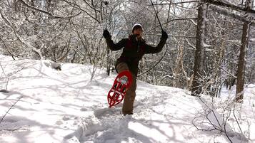 A person in a snowy forest holding a snowboard.