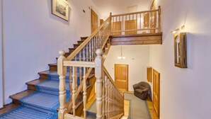A wooden staircase with a handrail leading to a landing.