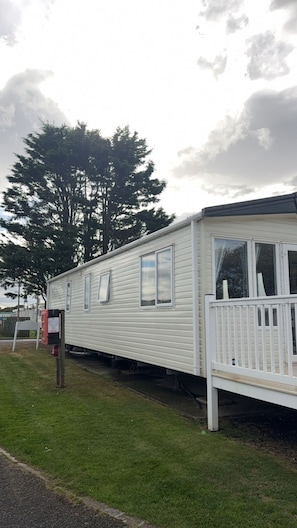 A mobile home with a front porch and a mailbox.