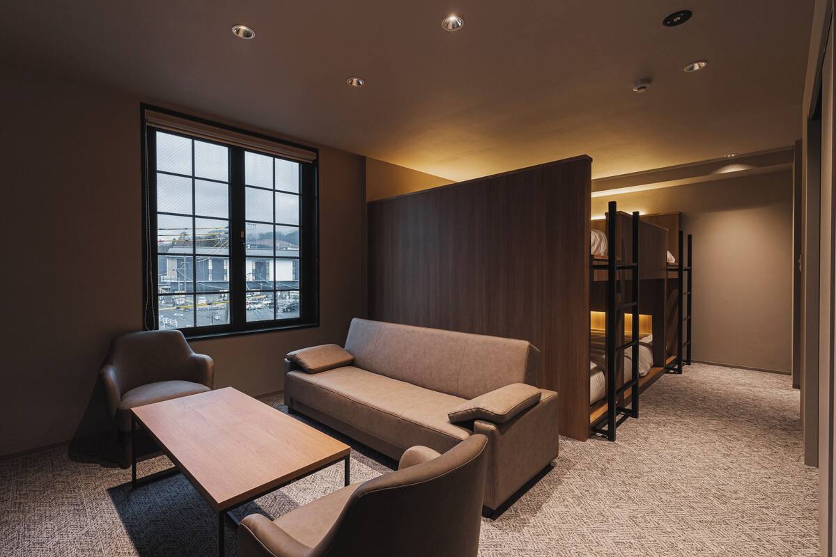 Una habitación de hotel moderna con sofá, una mesita y una ventana con vistas a la ciudad.