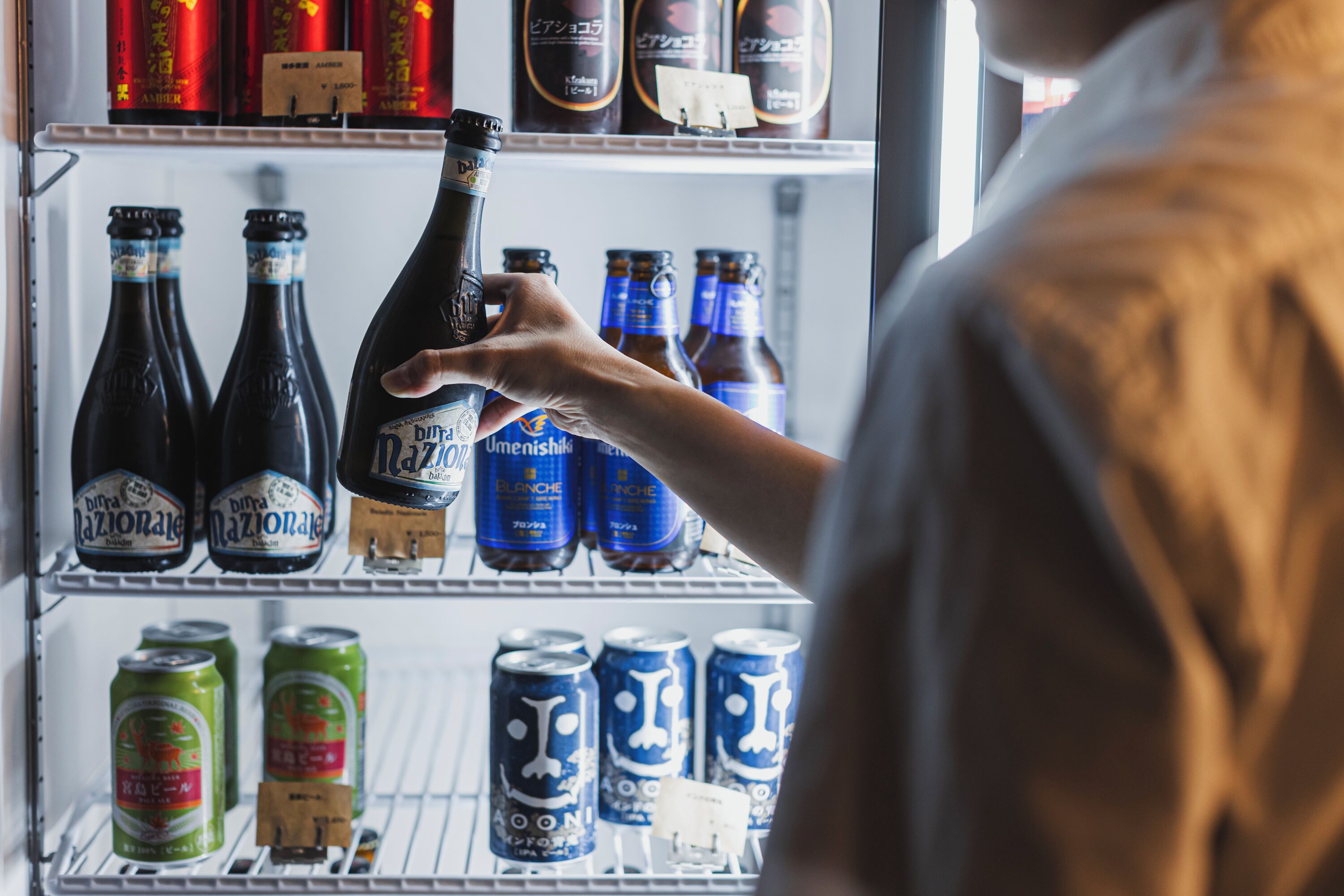 A refrigerator stocked with various beverages including bottles and cans.