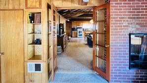 Un intérieur en bois comprenant un coin cuisine, une cheminée et une bibliothèque.