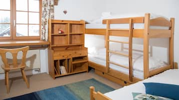 Une chambre avec un lit superposé, un bureau avec une chaise et une bibliothèque.