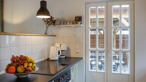 Een keuken met een fruitschaal, een koffiezetapparaat en een hanglamp.