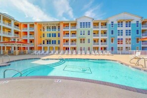 A multi-story hotel with a swimming pool, balconies, and a beach area. - Sojourn Dune it Right Sleeps 8 Great Views (Virginia Beach)