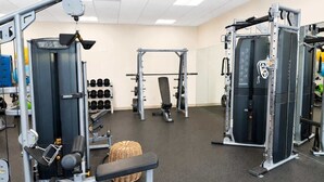 A gym with various exercise equipment, including weight machines and free weights.