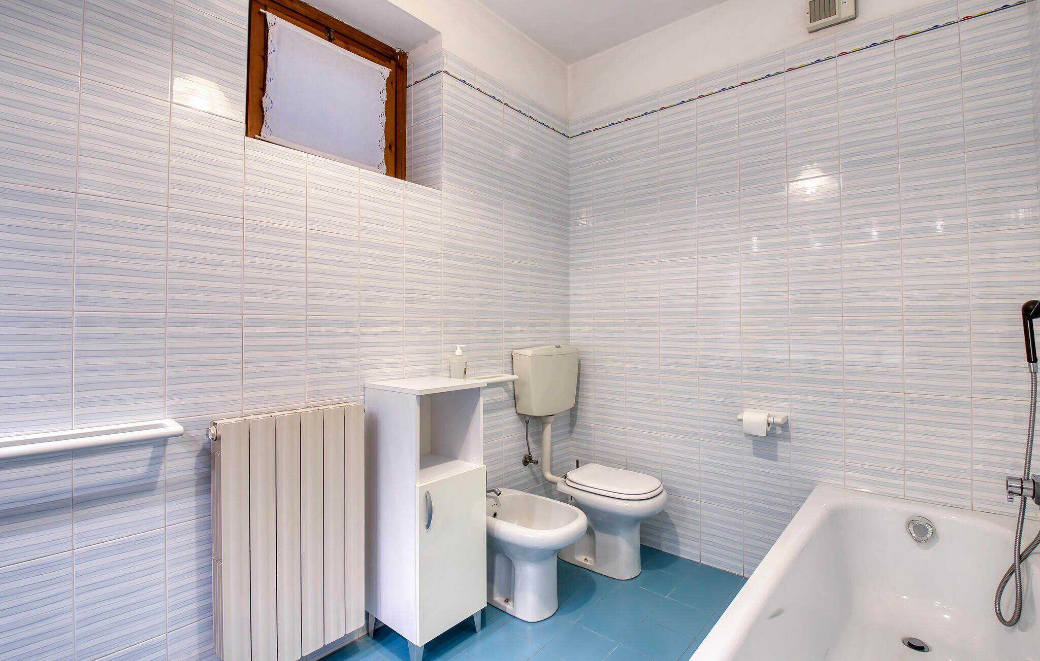 A bathroom with a toilet, bidet, and bathtub.