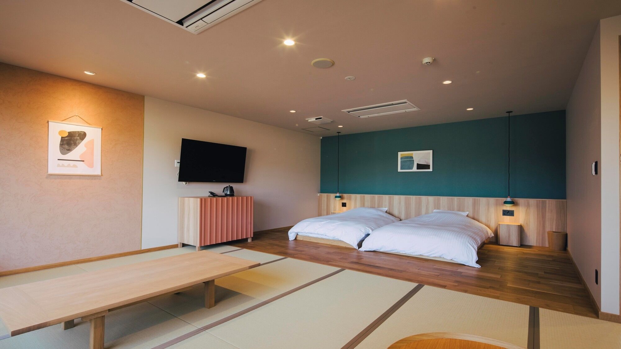 Habitación de hotel moderna con cama, mesitas de noche, televisor de pantalla plana, un banco de madera y un pequeño armario.