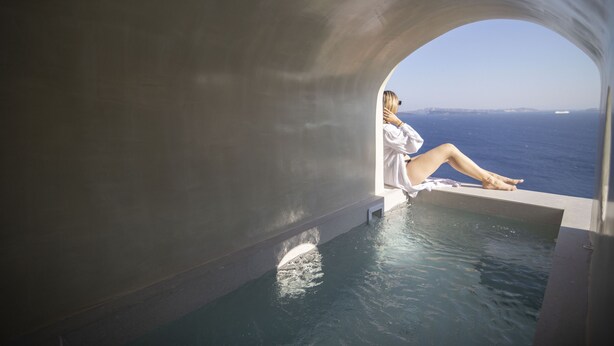 Eine Person entspannt sich in einem privaten Infinity-Pool mit Blick auf den Ozean.