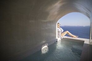 A person relaxing in a private infinity pool with a view of the sea. - Kyrkos Residency (Santorini)