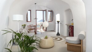 Ein modernes Wohnzimmer mit einem runden Couchtisch, einem Essbereich mit Tisch und Stühlen sowie einer Küchenzeile mit Spüle und Schränken.