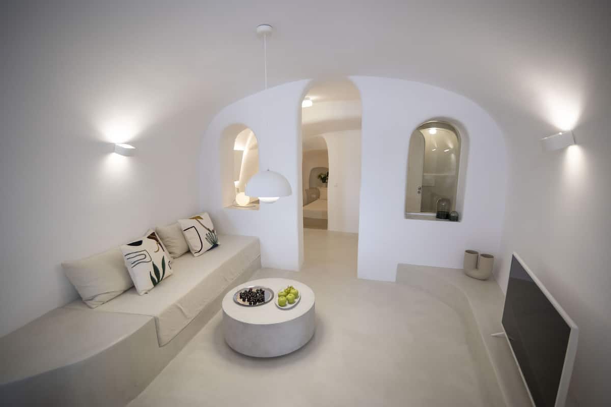 Una sala de estar moderna con un sofá, una mesa de centro y una televisión.