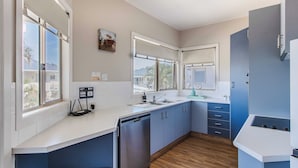 A modern kitchen with a dishwasher, a sink, and a countertop. - Hastings Cove 2 Bedroom Upstairs Estuary Water View Apartment (Tweed)