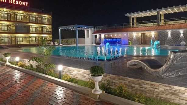 A swimming pool at night with a building labeled "Mini Resort" in the background. - Shinjini Resort (Kanthi)