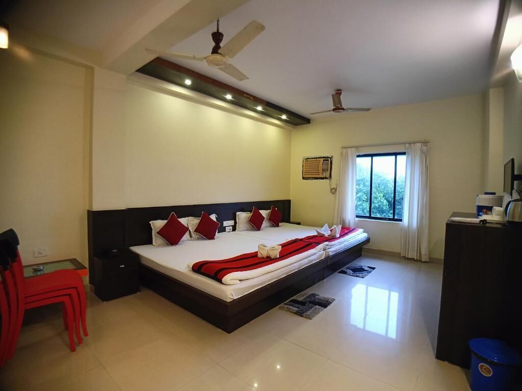 A modern hotel room with a large bed, a ceiling fan, a desk, and a window with curtains.