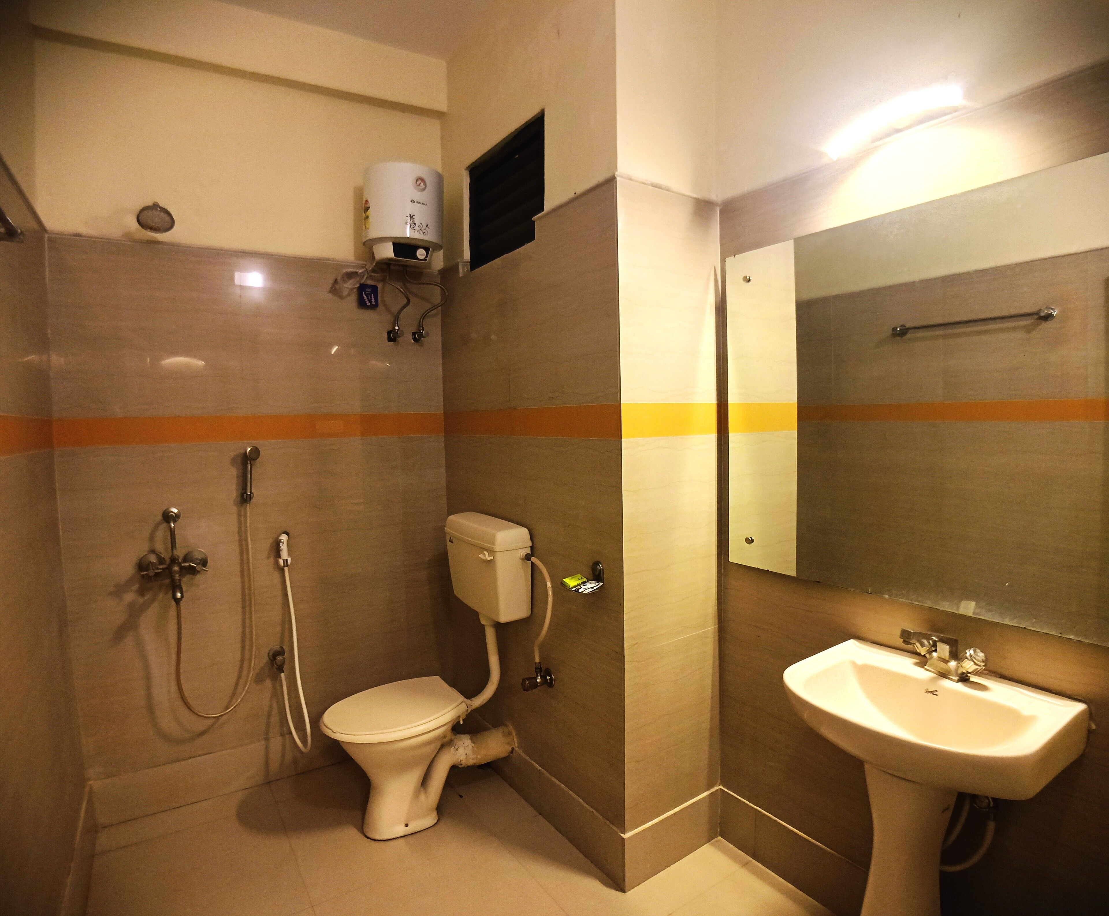 A bathroom with a toilet, shower, and sink.